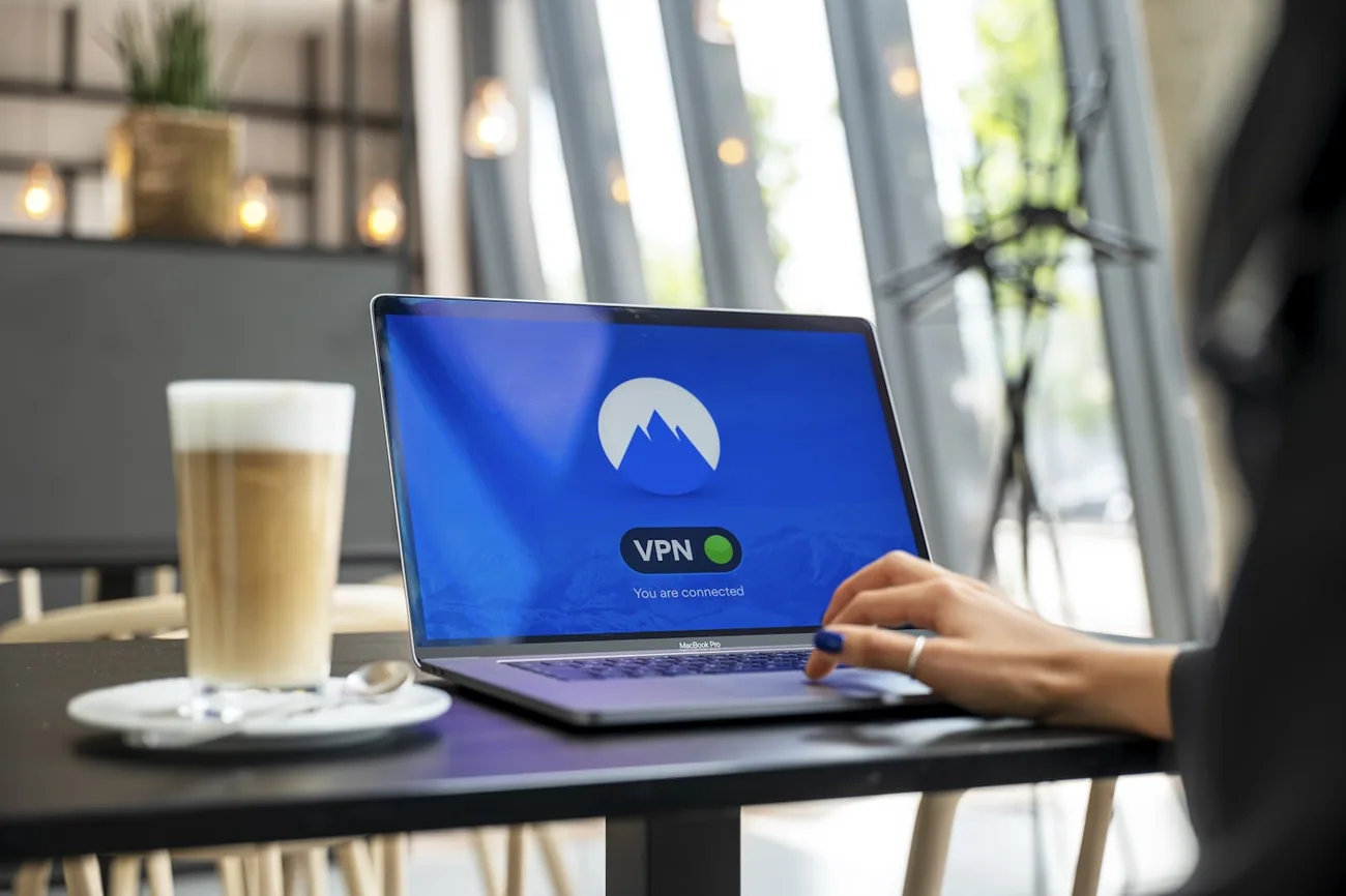 Bærbar PC med tilkoblet VPN-app på et kafébord ved vinduet
