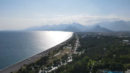 Utsikt fra høyden over den lange stranden i Antalya med Taurusfjellene bak byen