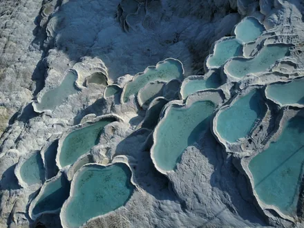Hvite kalkterrasser med turkise bassenger sett ovenfra i Pamukkale
