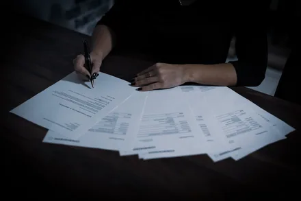 En person går gjennom papirer og skjemaer ved skrivebordet