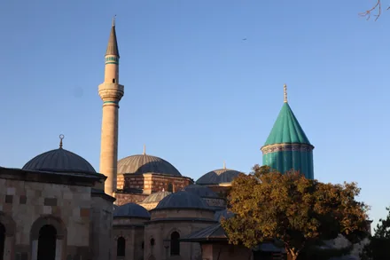 Mevlana-museets turkisblå kjegletårn og minaret over takene i Konya