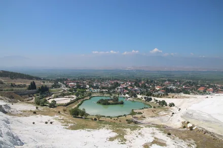 Utsikt fra de hvite kalkterrassene i Pamukkale ned mot landsbyen og sletta