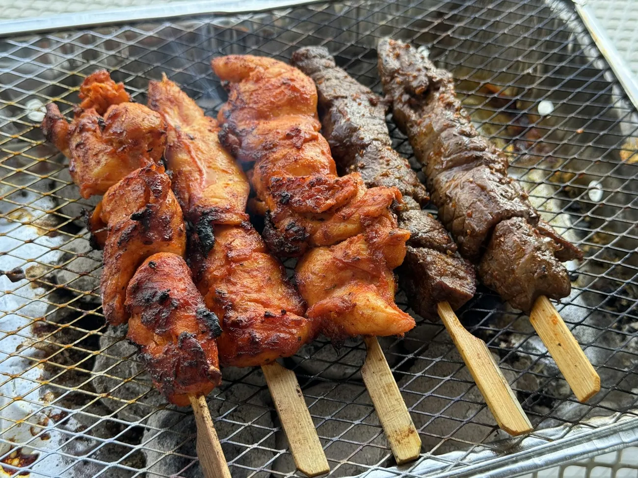 Ulike kebabspyd med kylling og kjøttdeig grillet over kull