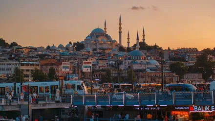 Bysilhuetten i Istanbul med moskeer og minareter mot rødlig kveldshimmel