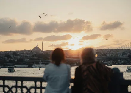 To personer ser på solnedgangen over Istanbul fra en bro over Det gyldne horn