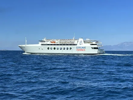 Passasjerferge på vei over åpent hav mot fjellene i horisonten