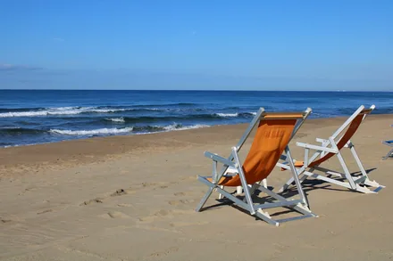 To tomme solsenger på en øde sandstrand ved blått hav