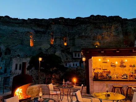 Opplyst terrasse på et hulehotell hugget inn i klippen i Kappadokia