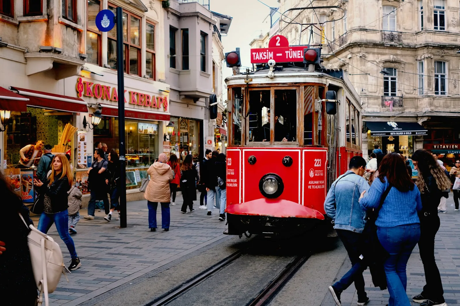 Den røde trikken i Istiklal-gaten i Istanbul, omgitt av fotgjengere