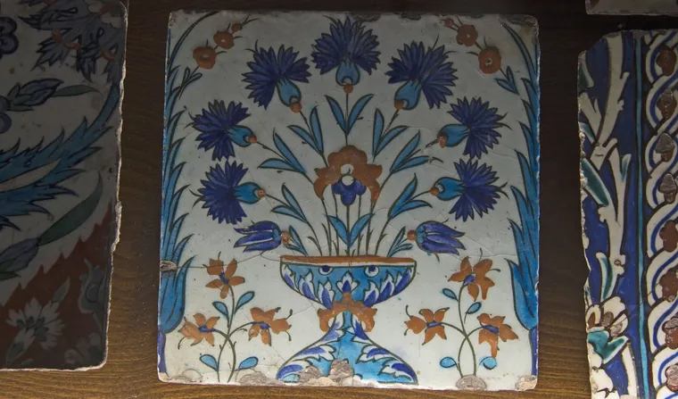 Håndmalt flisepanel med blå blomster på hvit bunn