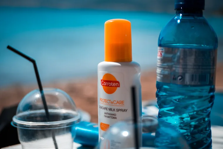 Solkrem og vann i strandvesken