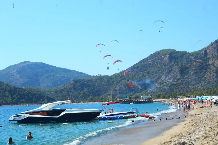 Paraglidere daler ned mot stranden ved Ölüdeniz